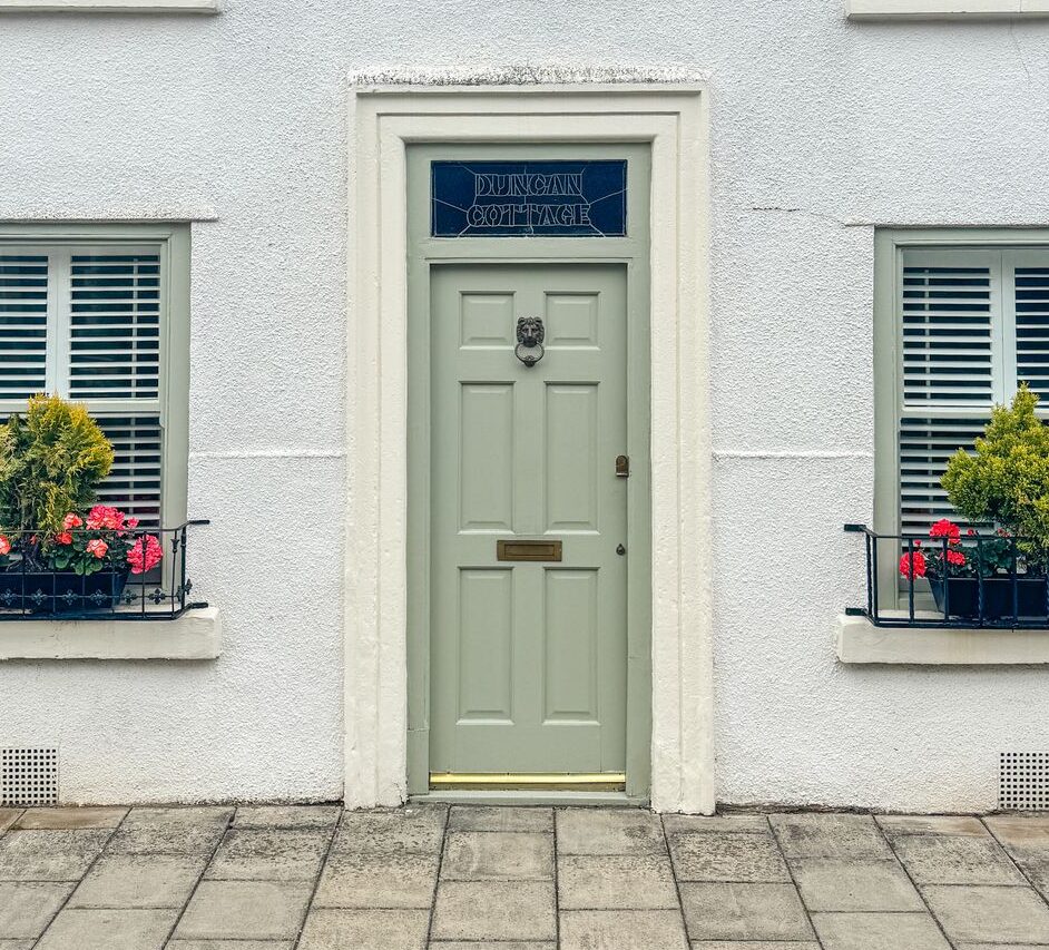 Beautiful sage door with a brass knocker.