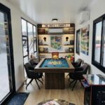 A garden cabin with pool table and retro arcade game.